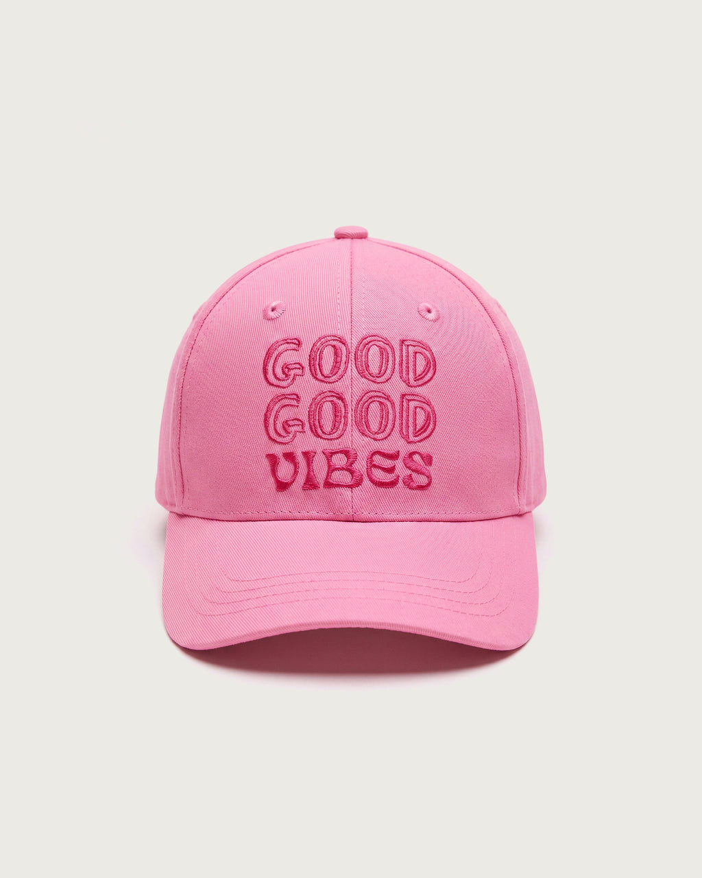 Rosafarbene Baseballkappe aus Baumwolle mit dreizeiligem, gesticktem Schriftzug „GOOD GOOD VIBES“ in dunklerem Pink auf der Vorderseite.