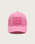 Rosafarbene Baseballkappe aus Baumwolle mit dreizeiligem, gesticktem Schriftzug „GOOD GOOD VIBES“ in dunklerem Pink auf der Vorderseite.