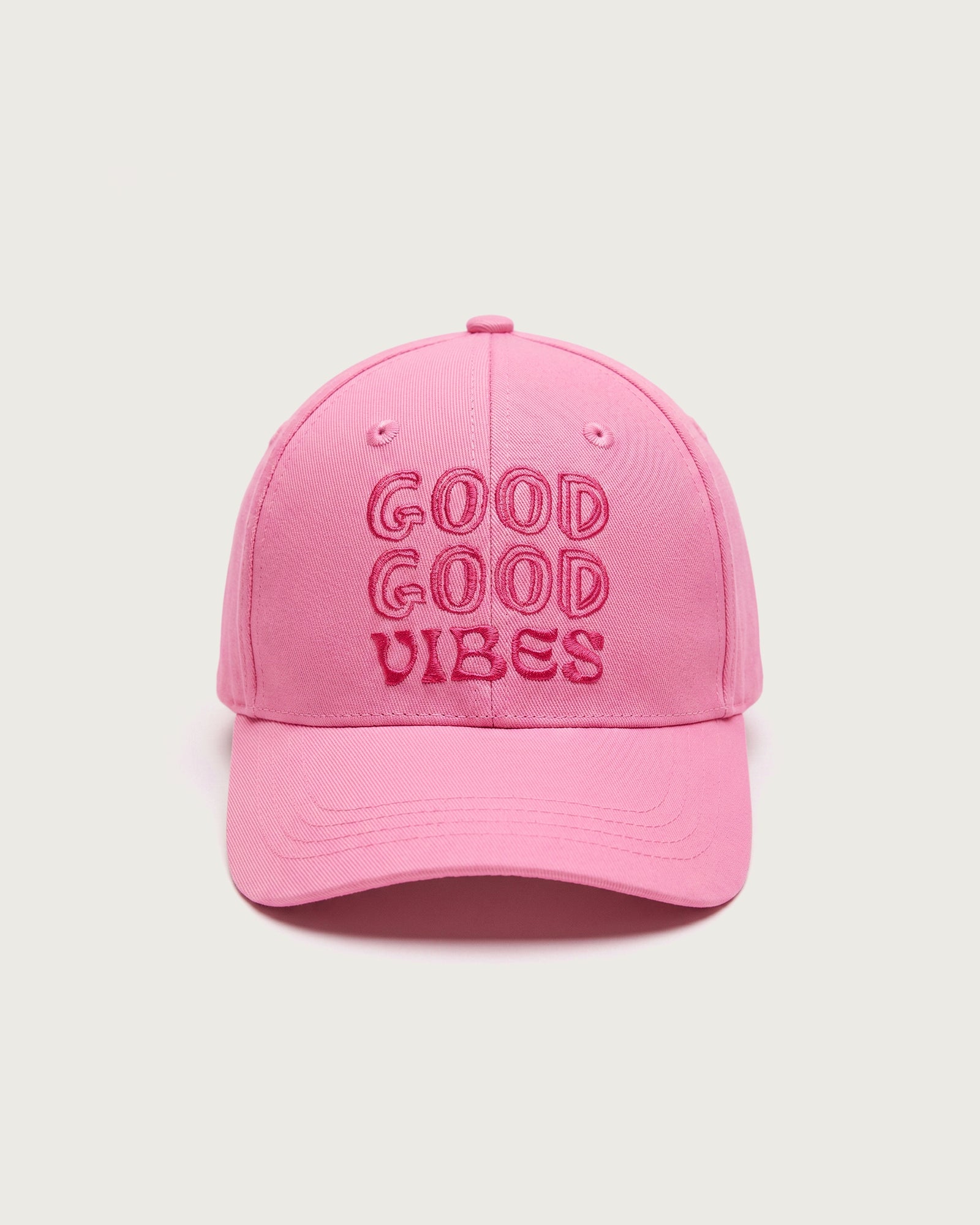 Rosafarbene Baseballkappe aus Baumwolle mit dreizeiligem, gesticktem Schriftzug „GOOD GOOD VIBES“ in dunklerem Pink auf der Vorderseite.
